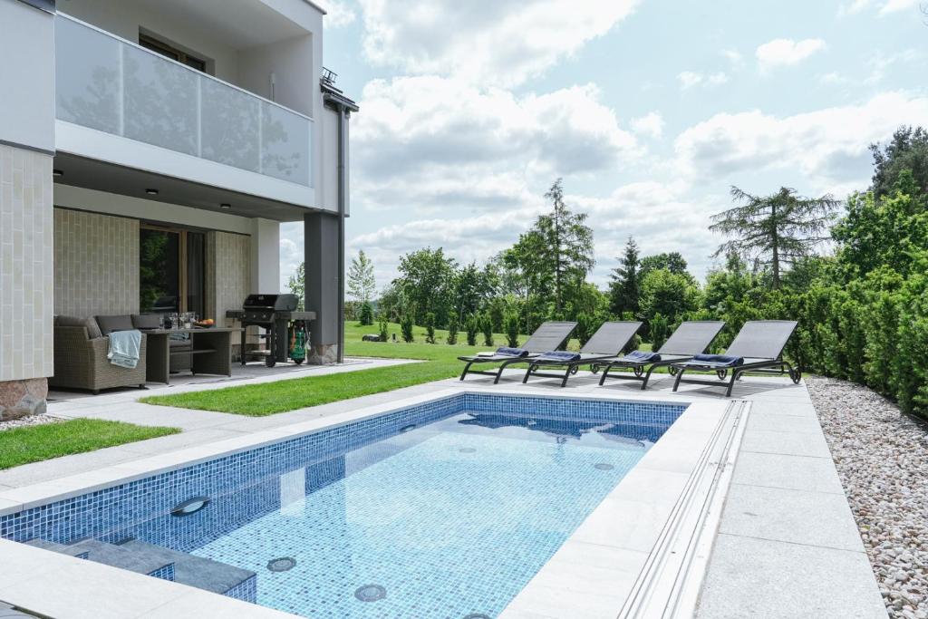 a swimming pool in the backyard of a house at Przystań Spokoju in Chmielno