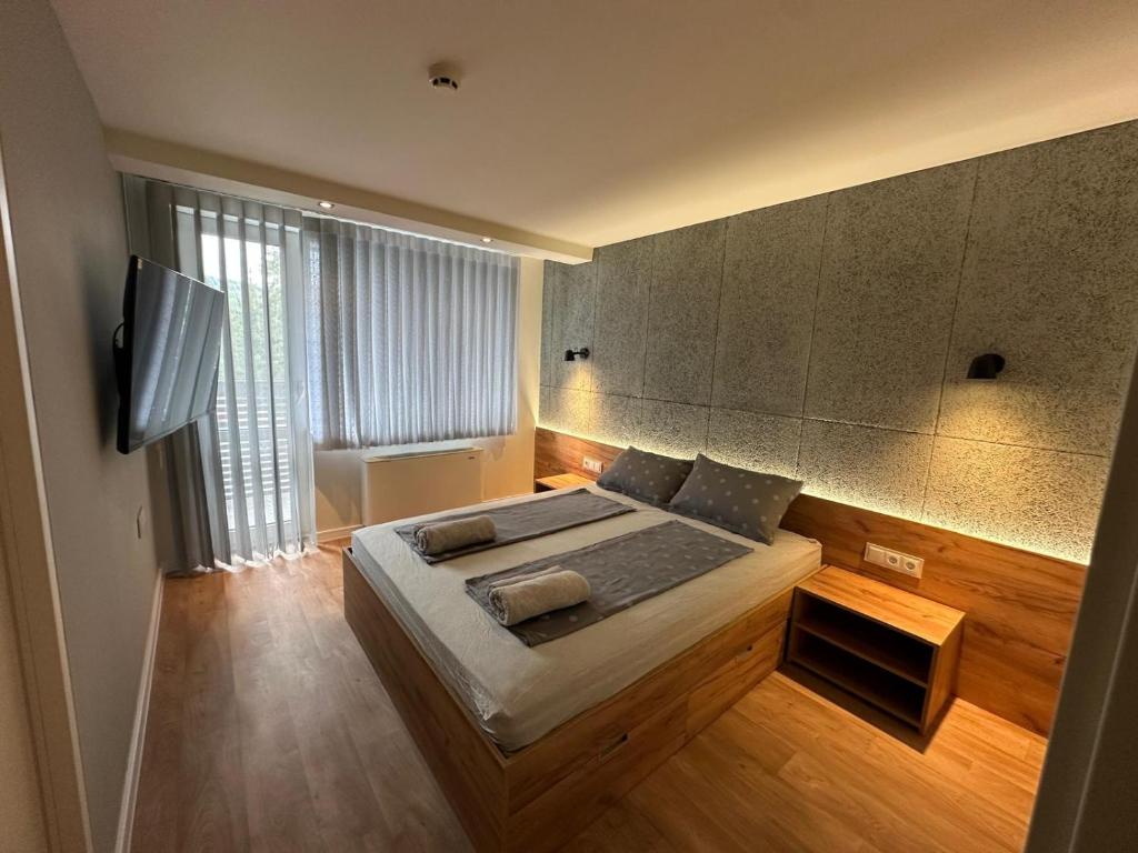 a bedroom with a bed and a flat screen tv at Приказна гледка B5 2 in Borovets