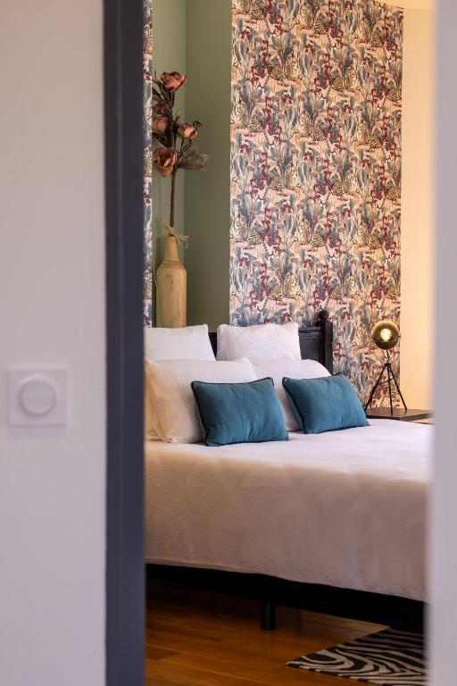 a bed with two pillows and a wall with a pattern at Capitole Horizon in Toulouse
