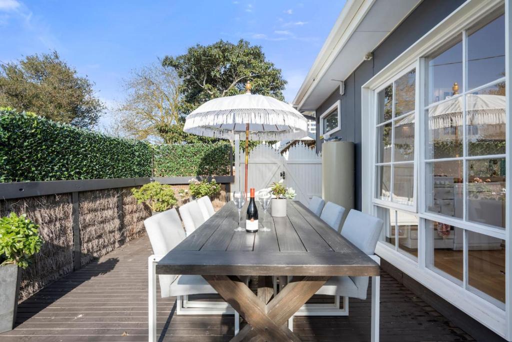 ライにあるEpic Group Escape - 900m Walk to Beach!のパティオに置かれた白い椅子と傘が付いた木製のテーブル