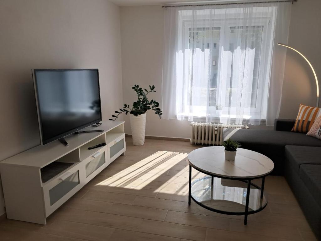 a living room with a tv and a couch and a table at Apartmán Dukla in Pardubice