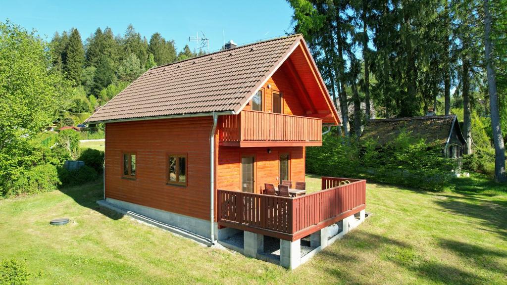 a small house with a deck on a yard at Kovarov26 in Frymburk