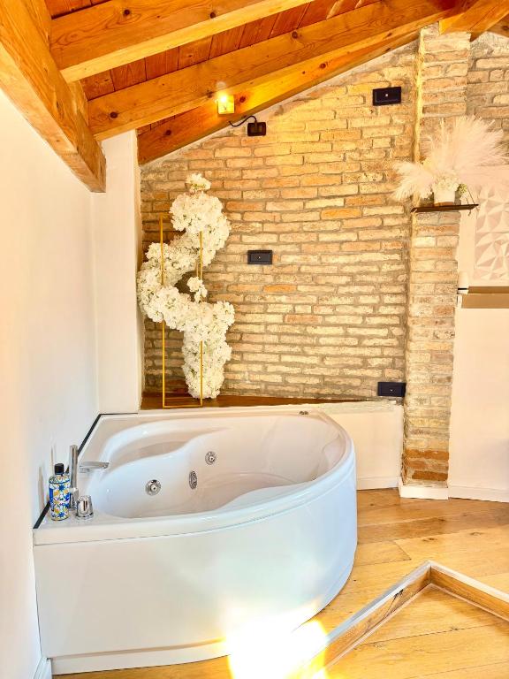 a bath tub in a room with a brick wall at Serenity in Mestre
