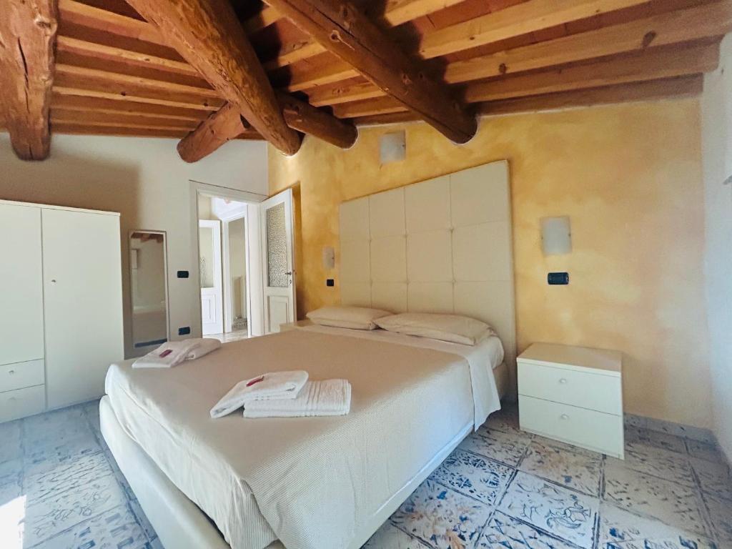 a bedroom with a large bed in a room with wooden ceilings at Residenza Eden in Colà di Lazise