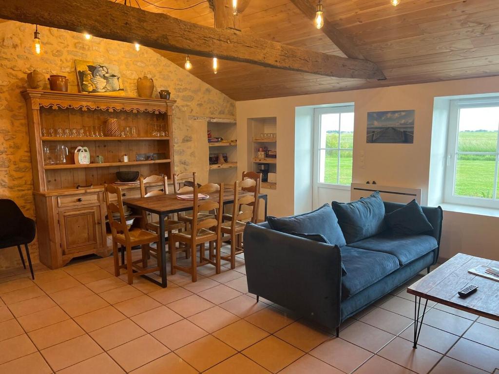 a living room with a couch and a table at L ETANG DES VACANCES Maison de charme au cœur des marais pour 6pers in Bouin