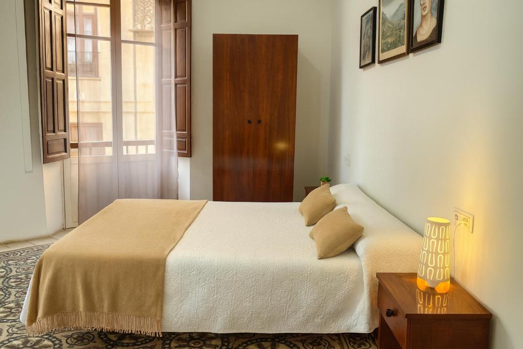 a bedroom with a bed and a table with a lamp at Casa Antares in Granada