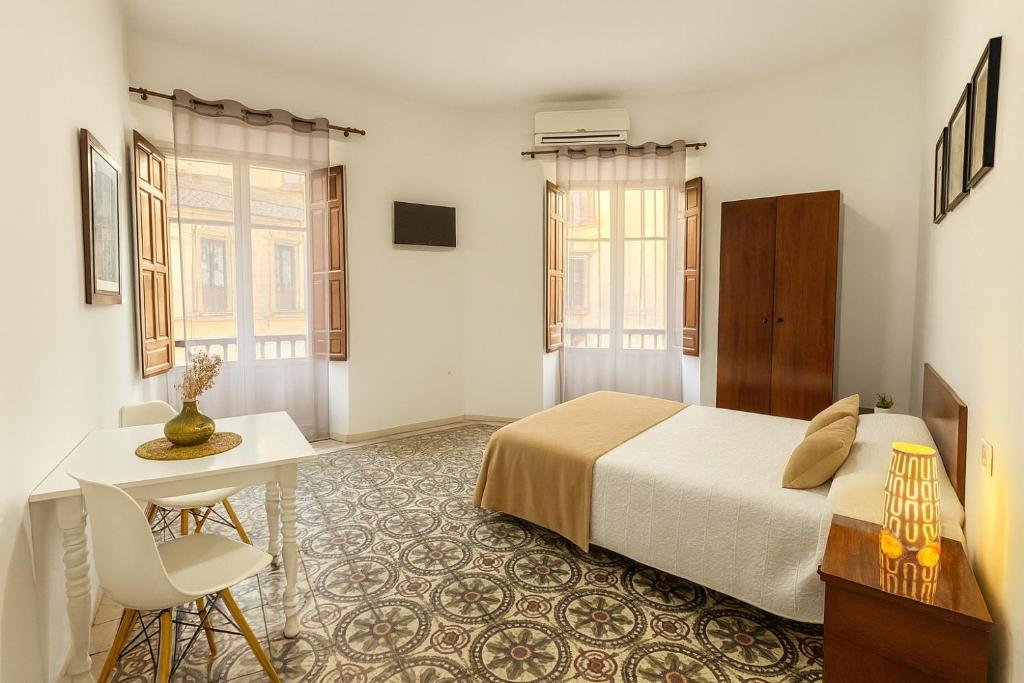 a bedroom with a bed and a table and a desk at Casa Antares Granada in Granada