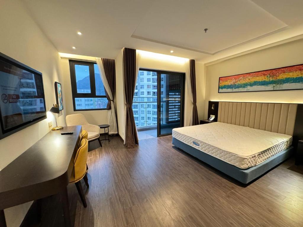 une chambre avec un lit et un bureau dans une pièce dans l'établissement The Sapphire City Park, à Hạ Long
