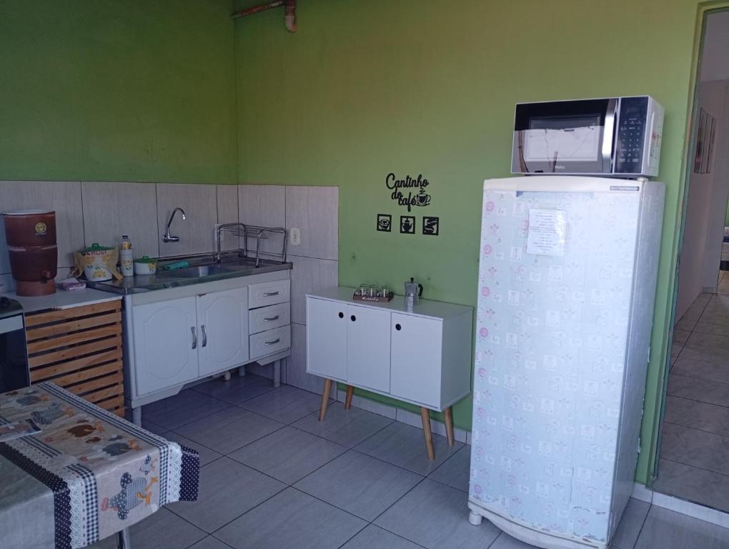 a kitchen with a microwave on top of a refrigerator at Casa Pôr do Sol in São Thomé das Letras