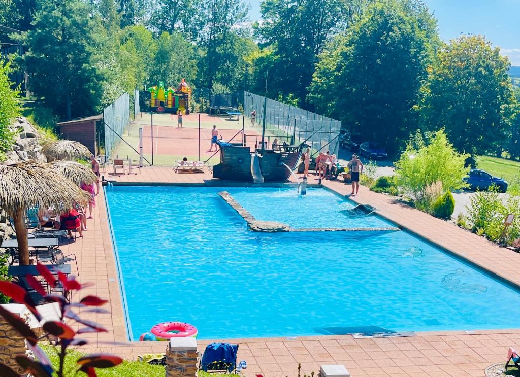 a large swimming pool with a pirate ship in it at Spa Hotel Podlesí - Walldorf a Pohádková vesnička in Podlesí