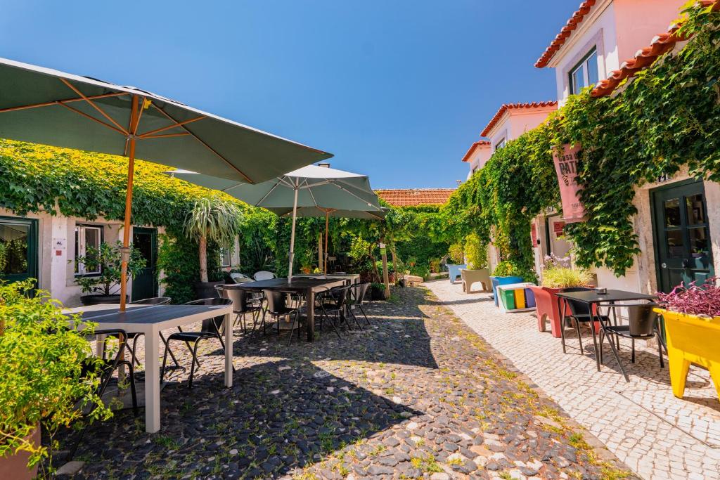 Un patio con mesas y sombrillas en un patio. en Casa do Patio by Shiadu, en Lisboa