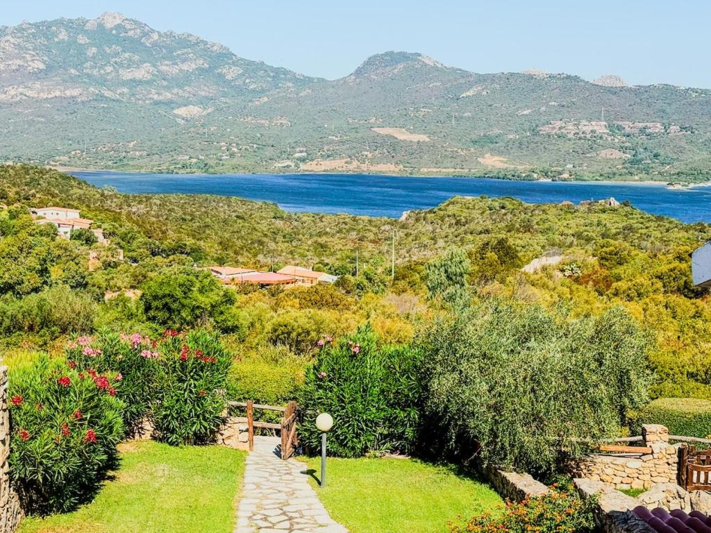 a garden with a view of a body of water at Casa Puni Porto Rotondo in Porto Rotondo