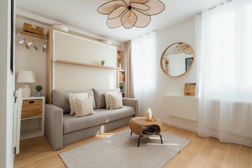 un salon avec un canapé et un miroir dans l'établissement Cosy studio près du Panthéon, à Paris