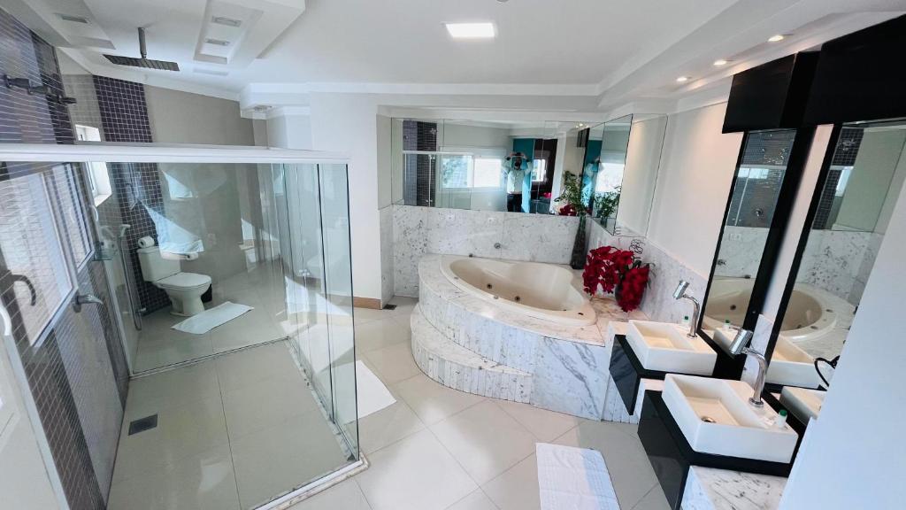 a large bathroom with a tub and a sink at SHELTON PALACE HOTEL in Paranavaí