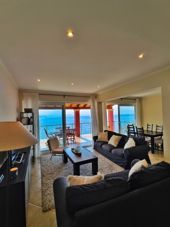 a living room with two couches and a table at Barbati Sunrise Suite in Barbati