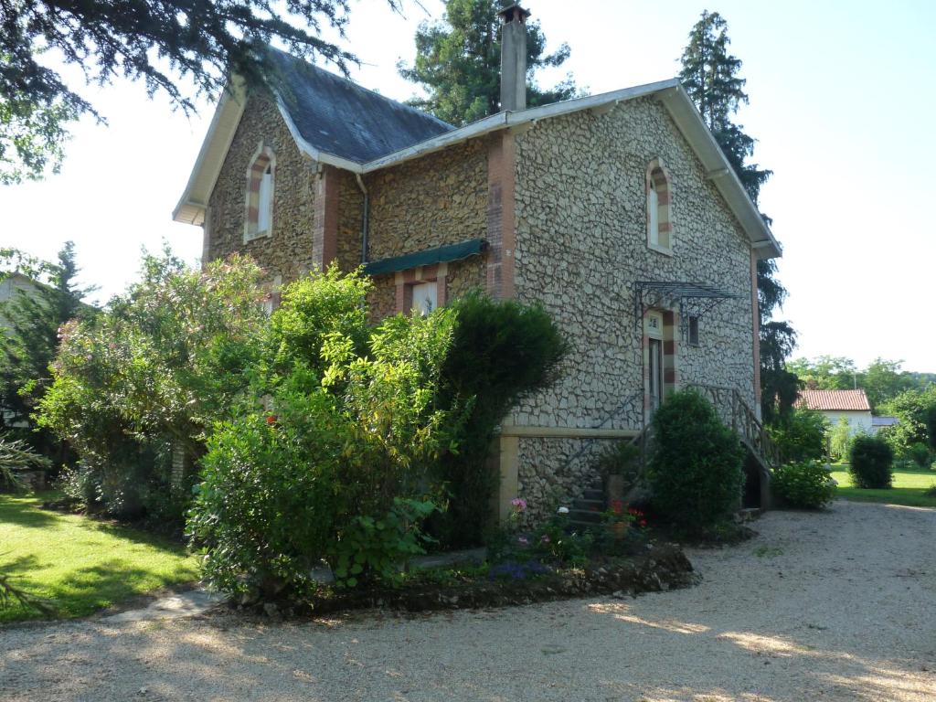 a stone house with bushes in front of it at Le point d'orgue in Pineuilh