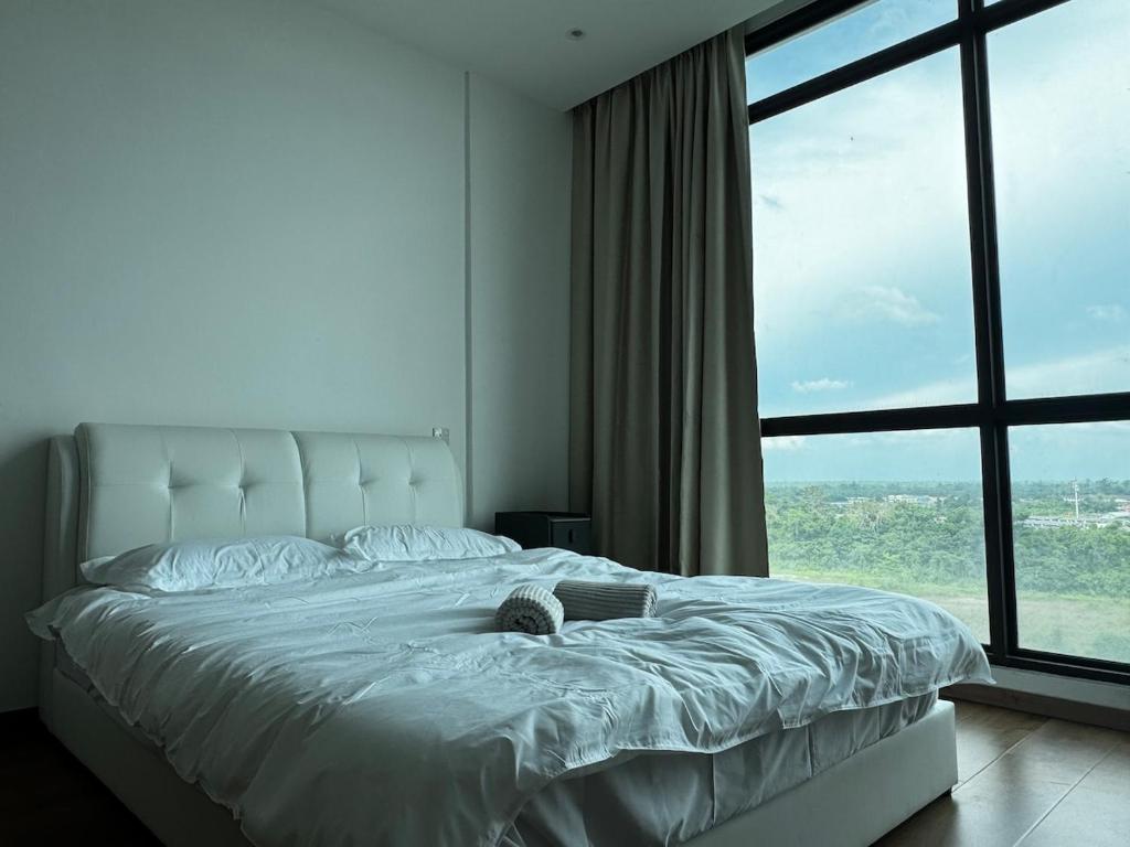 a bedroom with a large bed with a large window at Summermall suits samarahan in Kota Samarahan