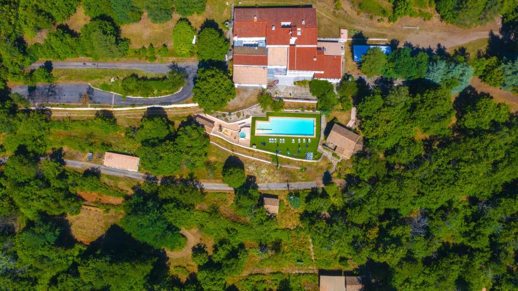 una vista aérea de una casa con piscina en un bosque en Centre de vacances Chausse, en Chamborigaud