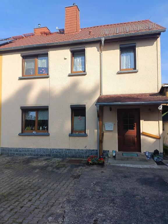a large white house with a red door at Silberranch Niederlichtenau in Lichtenau