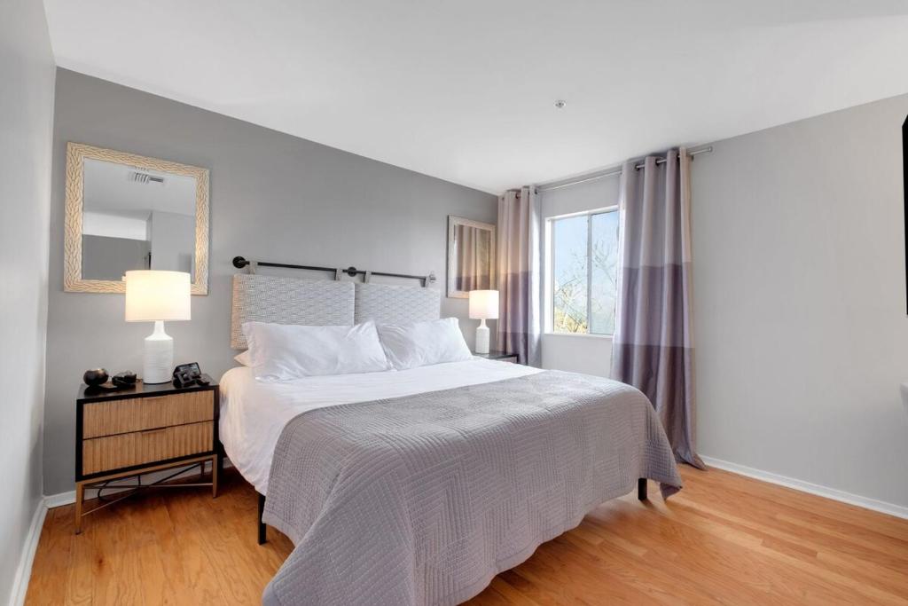 a white bedroom with a bed and a window at Downtown Nashville River Views Pool Parking in Nashville
