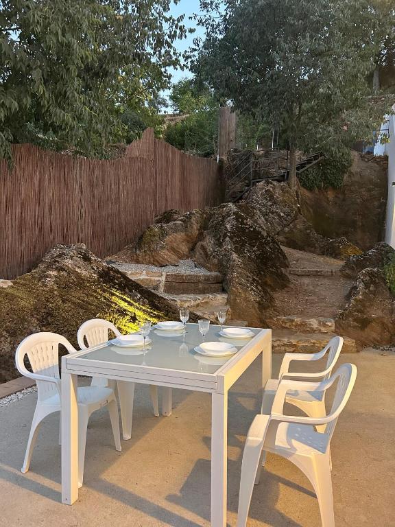 a white table with four chairs and a fence at Puerta de los Castañares A in Constantina
