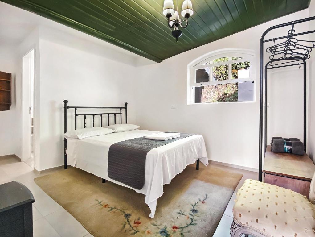 - une chambre avec un lit et un plafond vert dans l'établissement 2 suítes Lareira Jacuzzi Churrasqueira, à Campos do Jordão