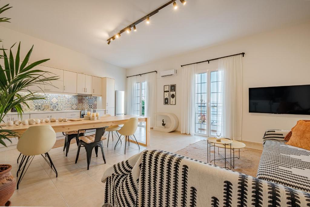 a kitchen and living room with a table and a couch at Porto Blu - Sea View Apartment in Kos Town