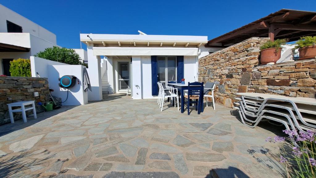 a patio with a table and chairs and a stone wall at Our dream, seaview, near the beach in Stelida