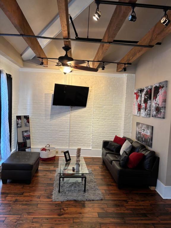 een woonkamer met een zwarte bank en een tv bij Sweet home decatur 305 , French Quarters Vieux Carré in New Orleans