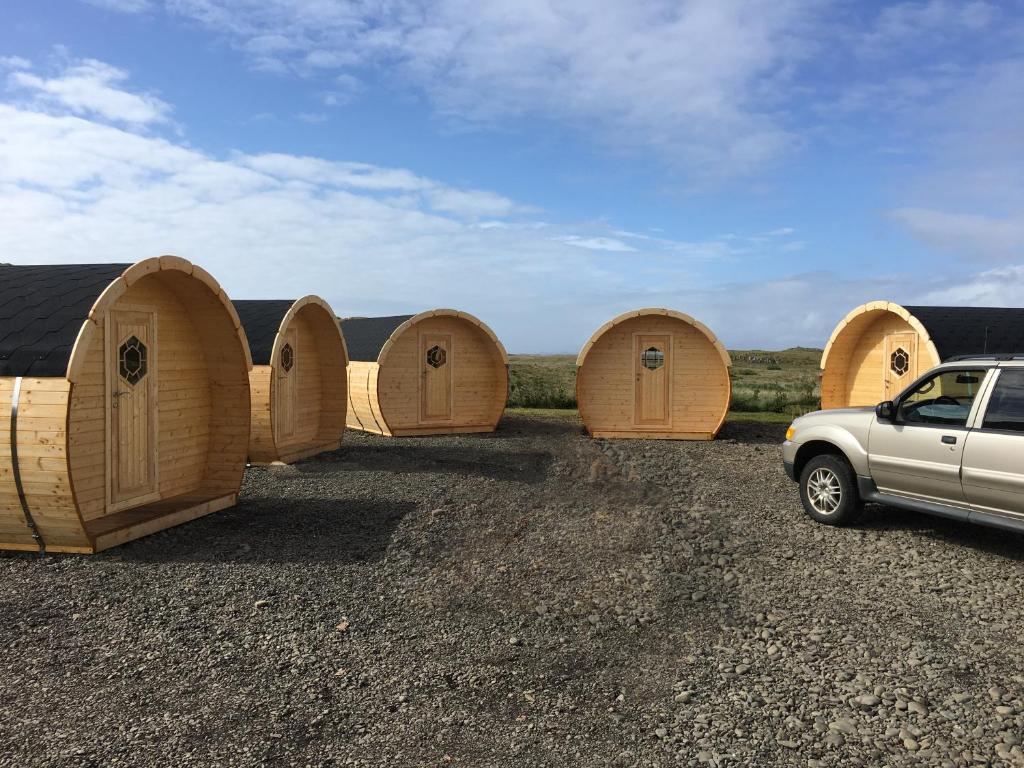 a row of wooden huts in a parking lot at Framtid Camping Lodging Barrels in Djúpivogur