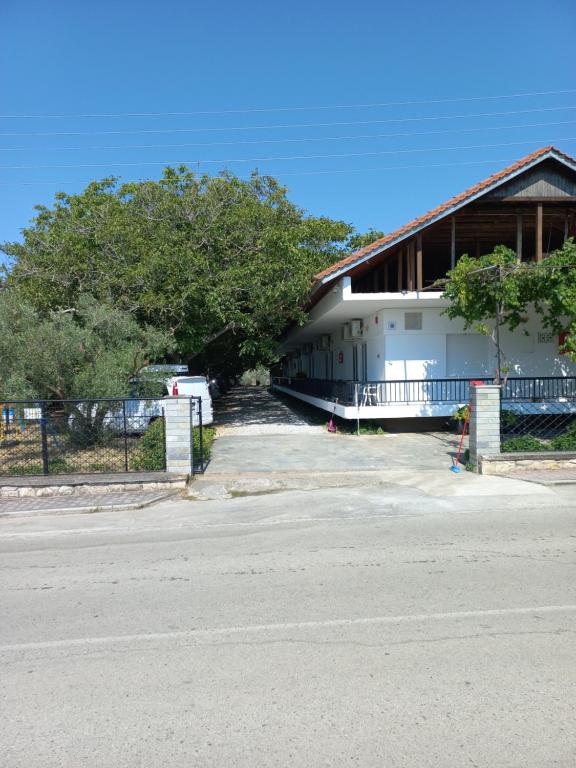 a building with a fence next to a road at PydnaRooms in Skála Alykís