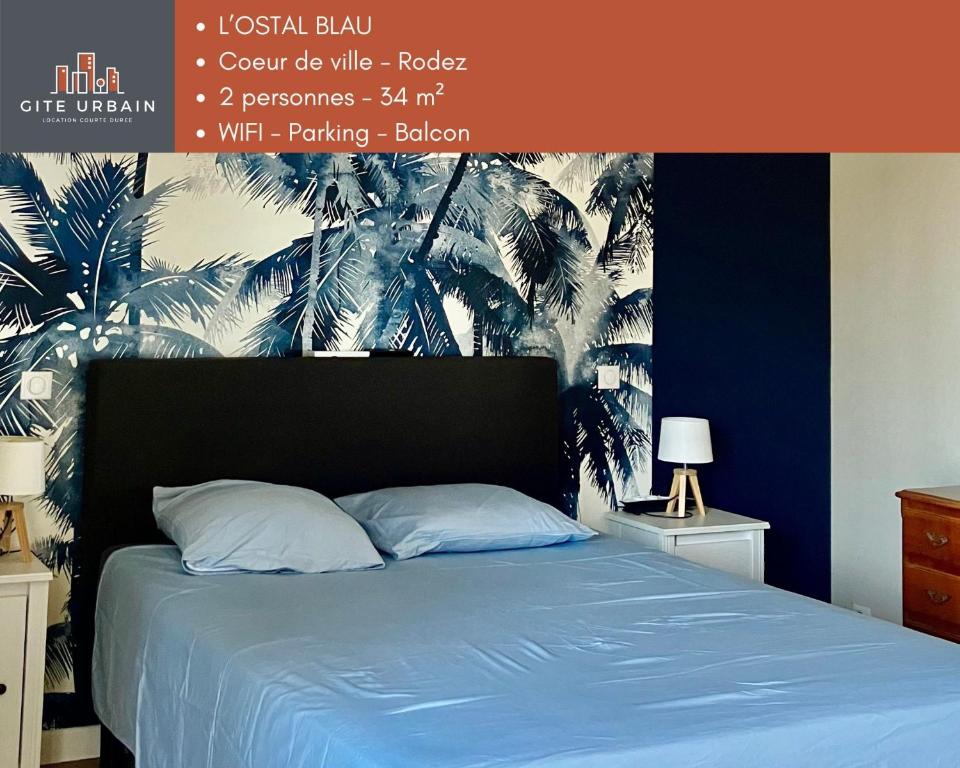 1 dormitorio con 1 cama azul y un mural de palmeras en l OSTAL BLAU, en Rodez