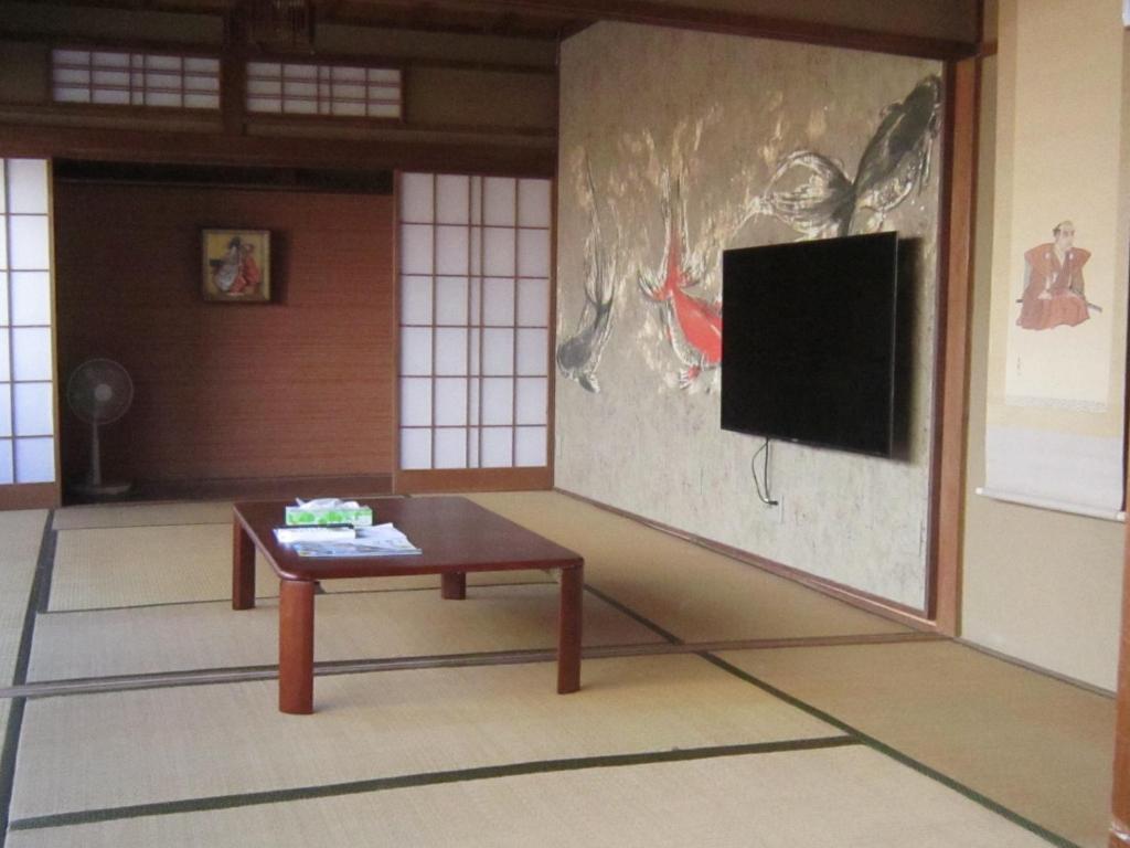 沼津市にあるNumazu - House - Vacation STAY 52025vのテーブルと壁にテレビが掛かっている部屋