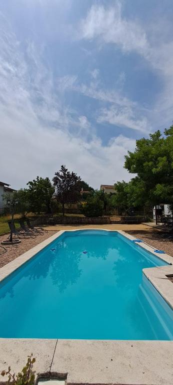 a large blue swimming pool in a yard at Casa da Mãe Ju in Porto de Mós