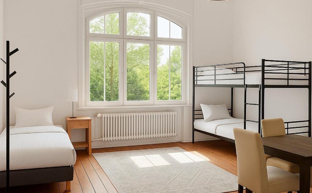 a bedroom with two bunk beds and a table at Ruhig in zentraler Lage mit Villen-Flair in Bad Kreuznach