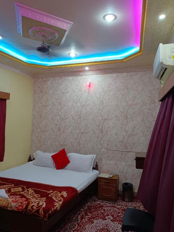 a hotel room with a bed with a purple lighting at New Hotel White Palace in kolkata