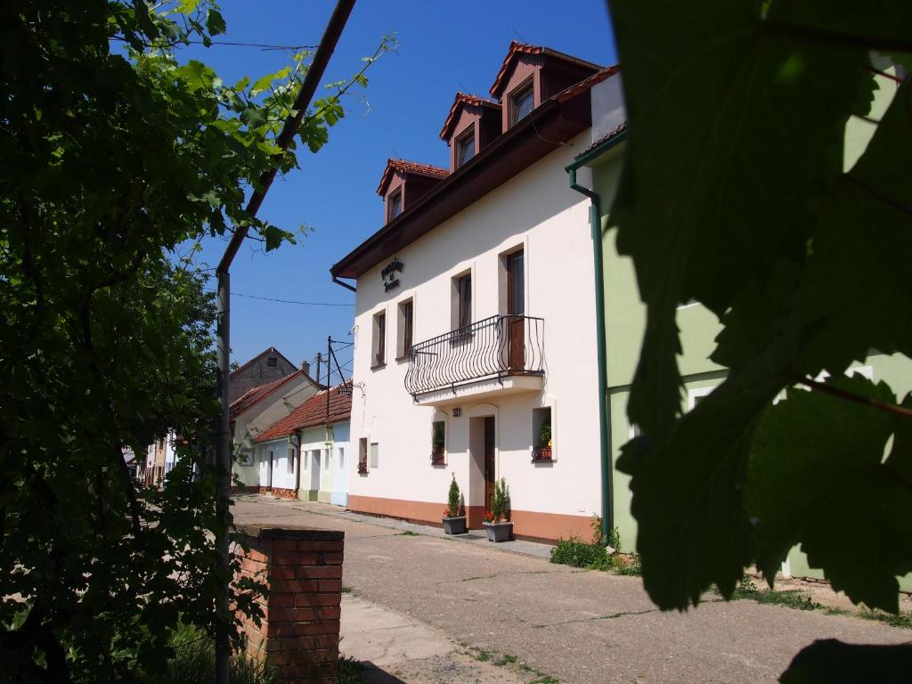 a white building with a balcony on a street at Penzion u Ivana in Bořetice