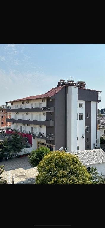 a large apartment building in front of a building at Hotel Kaloshi in Tirana