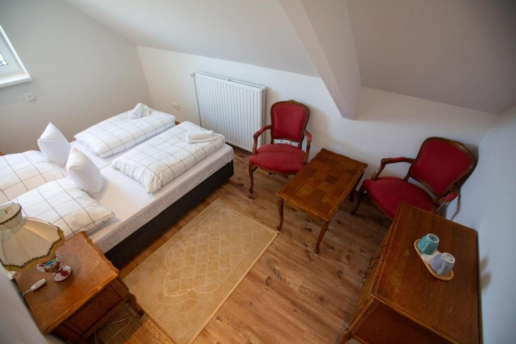 a bedroom with a bed and two red chairs at Villa Vintage Room B 107 in Tomášikovo