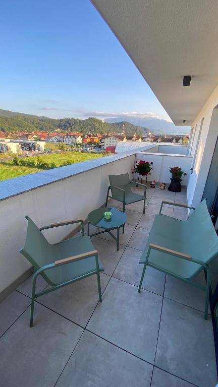 a balcony with green chairs and a view at Apartament Ovy Residence Râșnov in Râşnov