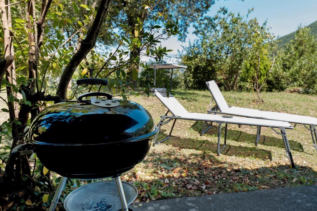 a grill and two lounge chairs in a yard at Villa Franca Nature Holidays in Rezzo