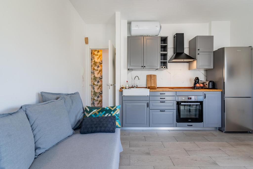 - une cuisine avec un canapé bleu dans une chambre dans l'établissement Enchanting and centric flat - Puerto de la Cruz, à Puerto de la Cruz