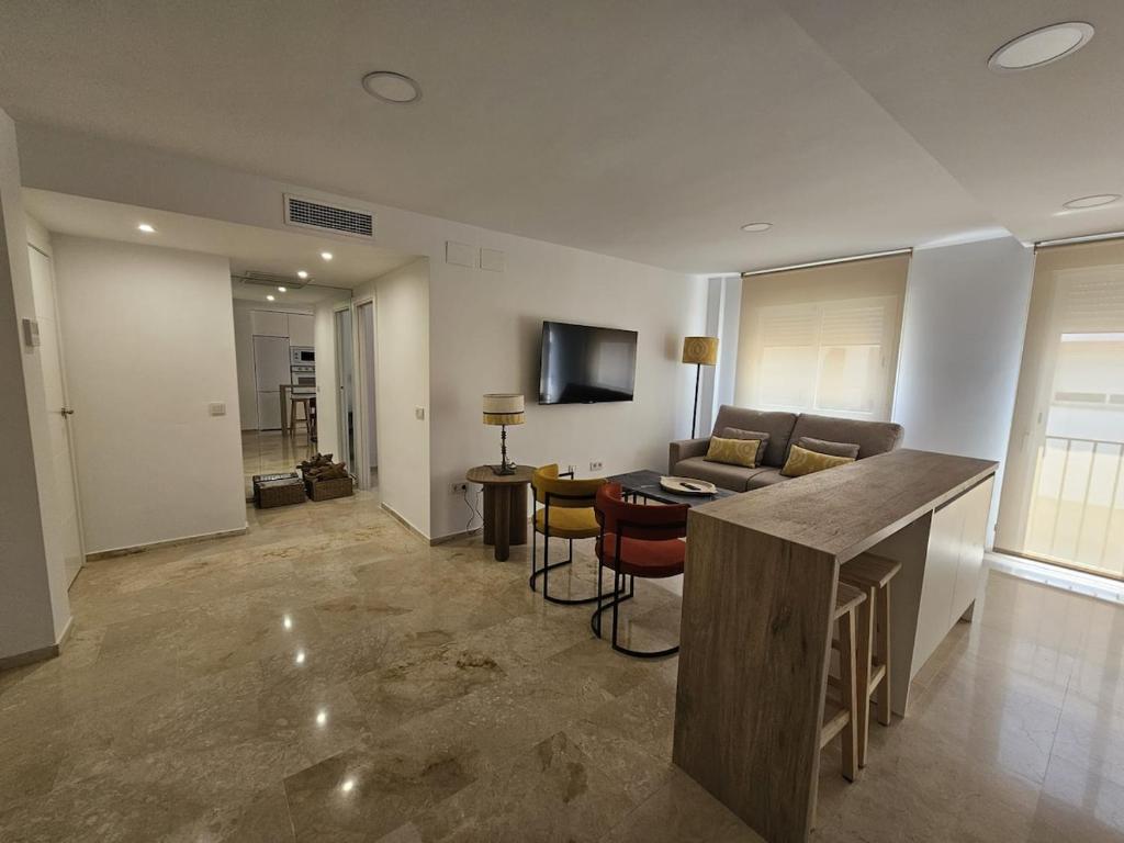 a kitchen and living room with a couch and a table at Apartamento Reyes Católicos in Córdoba