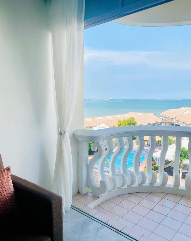 a room with a balcony with a view of the ocean at FA Seaview Glory Beach Resort in Port Dickson