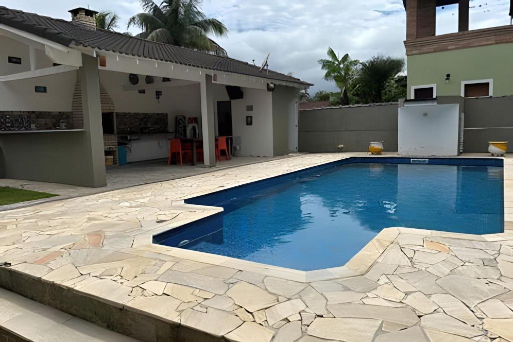 a swimming pool in the backyard of a house at Casa na Morada da Praia - Q83 in Bertioga
