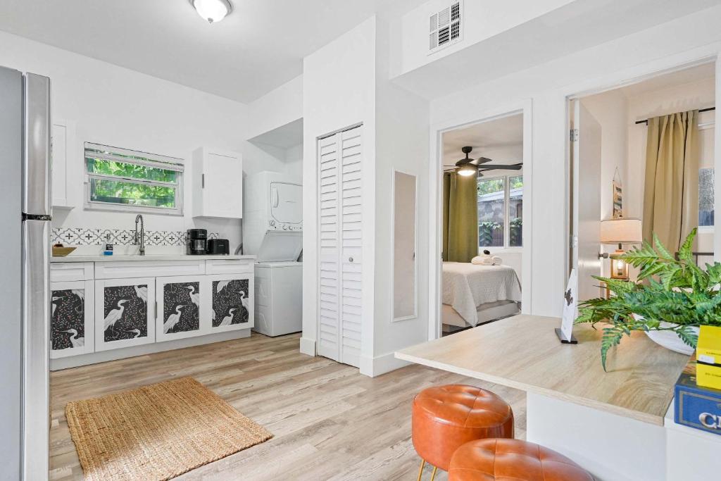 a kitchen and living room with white walls and wood floors at Havana Oh Na Na Unit C in Miami