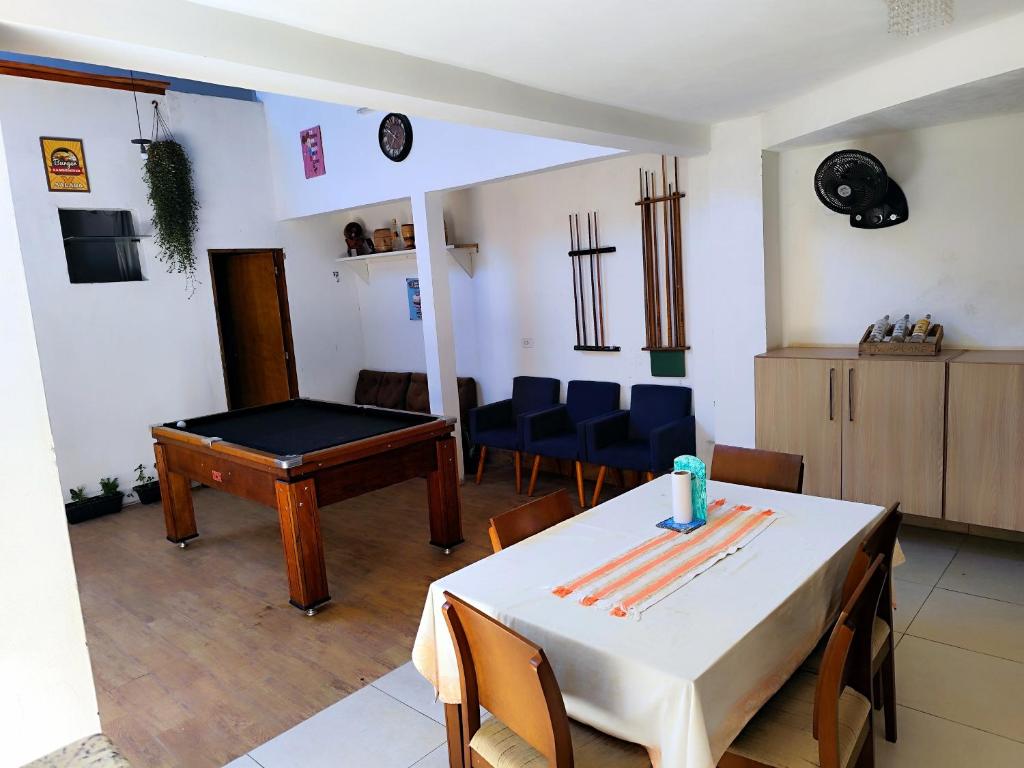 a living room with a table and chairs and a table sidx sidx sidx at Pousada 4 Estações in Botucatu
