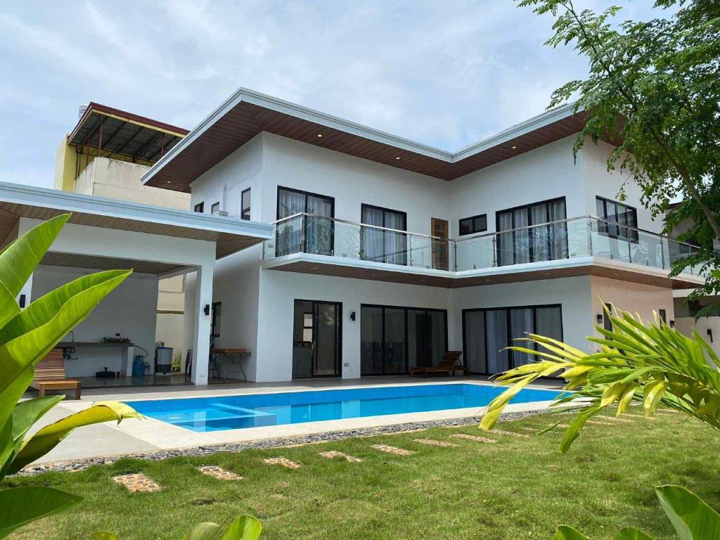 a house with a swimming pool in front of it at Villa Bella in Puerto Princesa City