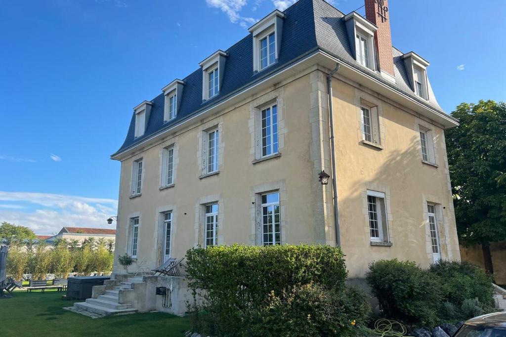 ランスにあるHôtel Particulier - 5 minutes de Reimsの上に塔がある大きな建物