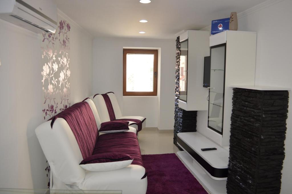 a living room with a white couch and a tv at Apartment Igor in Baška